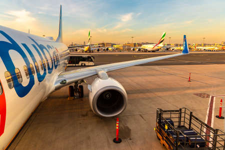 DUBAI, UAE - APRIL 5, 2020: Airplane Flydubai Boeing 737-800 at Dubai International Airport at sunset, Dubai, United Arab Emiratesのeditorial素材