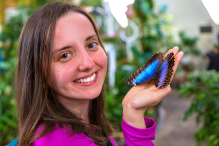 Young woman playing with a butterfly