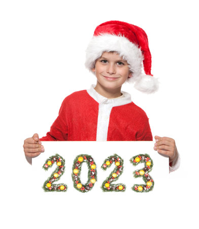 Boy Santa Claus is holding a christmas poster and 2023 number made by christmas tree branches...