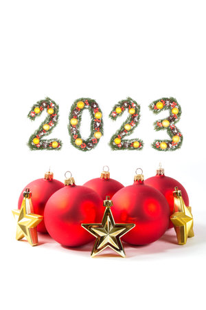 Red christmas ball and 2023 number made by christmas tree branches isolated on white background