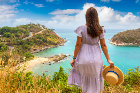Woman traveler wearing blue dress and straw hat at   Panoramic view of  Yanui Beach at Phuket in Thailand in a summer dayの写真素材