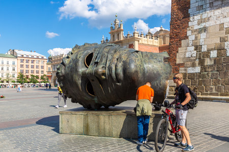 KRAKOW, POLAND - SEPTEMBER 11, 2022: Eros Bendato (Eros bound) giant head statue in Market square in a sunny day in Krakow, Polandのeditorial素材