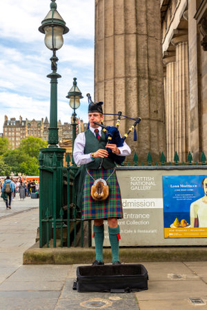 EDINBURGH, UK - JUNE 11, 2022: Bagpiper playing music with bagpipe near Edinburgh Castle in Edinburgh, Scotland, UKのeditorial素材