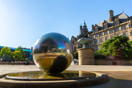 SHEFFIELD, UK - JUNE 16, 2022: The sculpture stainless steel spheres and Sheffield Town Hall in a sunny summer day in Sheffield, South Yorkshire, UKのeditorial素材