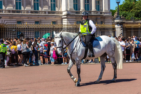 LONDON, UK - JUNE 17, 2022: Metropolitan mounted police patrolling at changing of the guard ceremony in front of Buckingham Palace in London in a sunny summer day, UKのeditorial素材