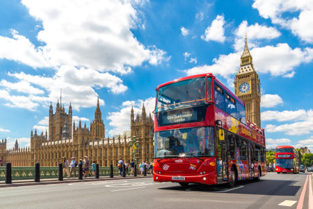 LONDON, THE UNITED KINGDOM - JUNE 26, 2022: Open-top Hop-on Hop-off Bus - City Sightseeing London on the Westminster Bridge and Big Ben and Palace of Westminster  in London, England, UKのeditorial素材