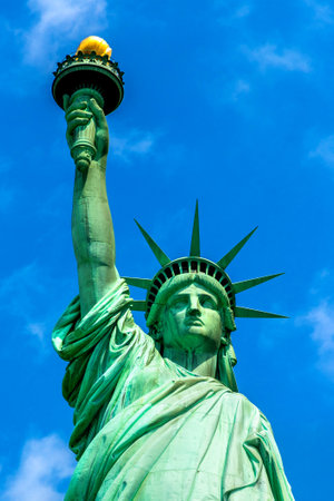 Statue of Liberty against blue sky with beautiful cloud background in New York City, NY, USAの写真素材
