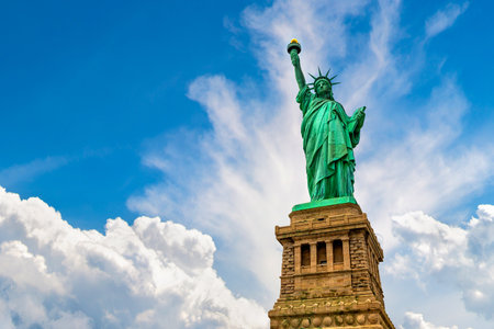 Statue of Liberty against blue sky with beautiful cloud background in New York City, NY, USAの写真素材