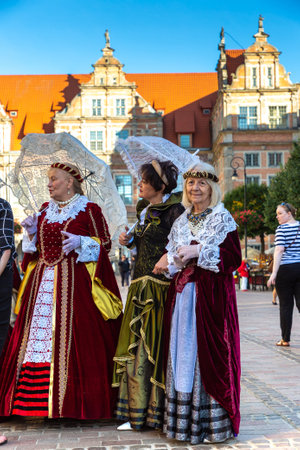 GDANSK, POLAND - SEPTEMBER 7, 2022: Group of women dressed in Polish national traditional folk dress in a beautiful old town in Gdansk, Polandのeditorial素材