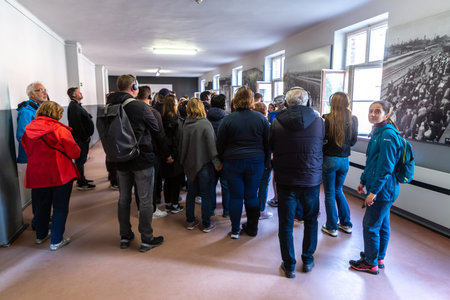 OSWIECIM, POLAND - SEPTEMBER 7, 2022: Group of tourists at Photo Exhibition in Auschwitz...