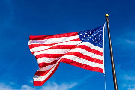 USA flag waving in clear blue skyの写真素材
