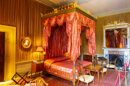 YORKSHIRE, UK - JUNE 30, 2025: Antique Luxurious Castle Howard bedroom with red canopy bed and classic decor in North Yorkshire, England, United Kingdomのeditorial素材