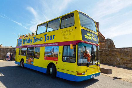 WHITBY, UK - JUNE 29, 2025: Yellow Open Top Double Decker sightseeing bus for the Whitby Town Tour in Whitby, North Yorkshire, England, United Kingdomのeditorial素材