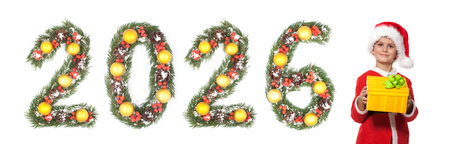 Smiling boy dressed as Santa Claus holding Christmas gift box standing beside 2026 number made from...