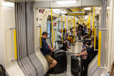 LONDON, UK - MAY 08, 2024: Interior of London Underground tube train with passengers carrying luggage during travel in London, England, United Kingdomのeditorial素材