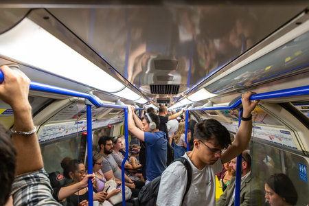 LONDON, UK - AUGUST 26, 2024: Passengers in a crowded London Underground tube train carriage during...