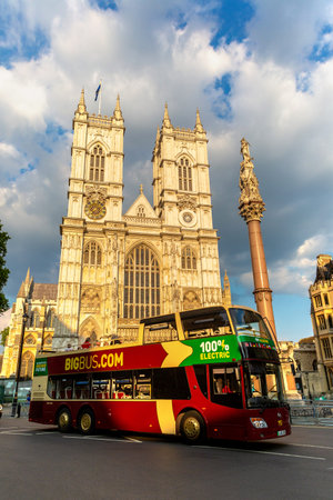 LONDON, UK - JUNE 26, 2024: Big Bus London electric tour bus drives past Westminster Abbey at sunset in London, England, United Kingdomのeditorial素材