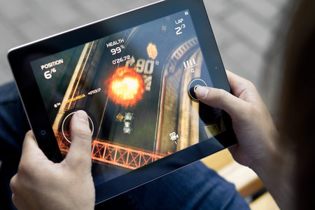 Kiev, Ukraine - June 05, 2011 - A man outdoors play in the game Death Rally on Apple Ipad2. This...