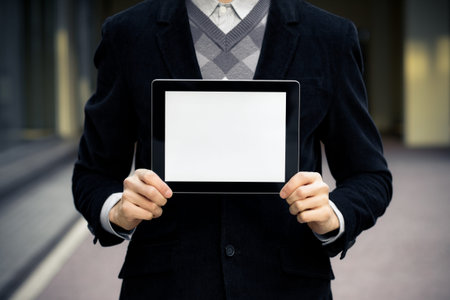 Businessman shows digital tablet pc with blank screen.