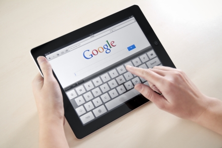 Kiev, Ukraine - December 03, 2011: Woman hands holding and touching on Apple iPad2 with Google search web page on a screen. This second generation Apple iPad2 is designed and development by Apple inc. and launched in march 2011.のeditorial素材