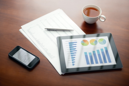 Modern workplace with digital tablet and mobile phone, pen and papers with numbers の写真素材