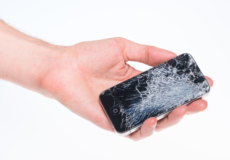 Kiev, Ukraine - January 25, 2013: Hand holding Apple iPhone 4 with broken screen, studio shot. Apple iPhone 4 developed by Apple inc. in June, 2010. のeditorial素材