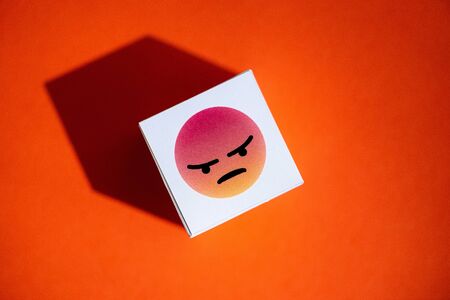Kyiv, Ukraine - September 5, 2019: An anger emoji symbol from Facebook Messenger printed on a paper cube. Facebook Messenger one of the biggest and world-famous social networks.のeditorial素材