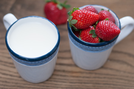 Cups filled with  fresh stawberries and milkの写真素材
