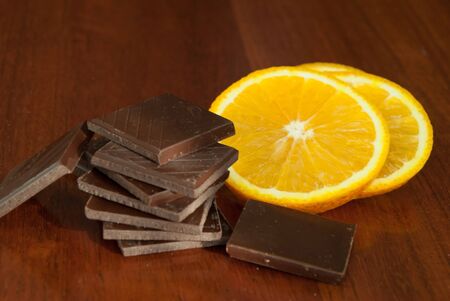 Chocolate, nuts, berries and orange on glossy wooden backgroundの写真素材