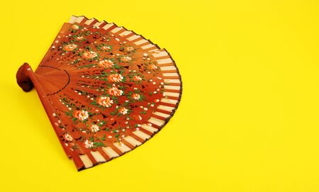 Stylish Classic Spanish Hand Fan on Bright Yellow Background. .の写真素材