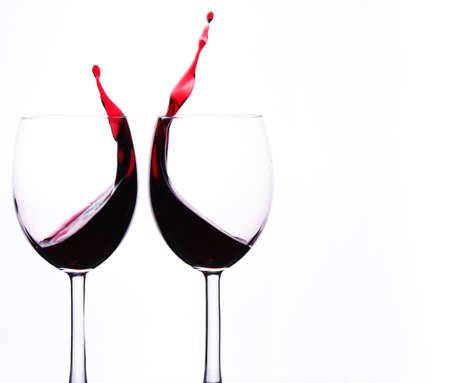 Two Crystal Wine Glasses with Red Wine and Splashes.の写真素材