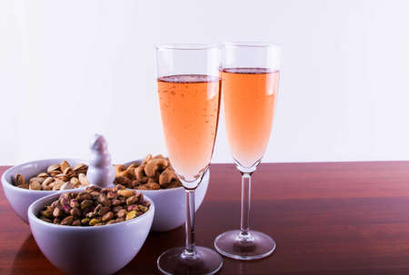 Glass of Pink Sparkling Wine with Nuts Mixed. .の写真素材