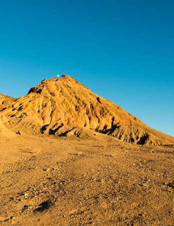Moon seen above mountain peak at sunset in Death Valley, California, USAの写真素材