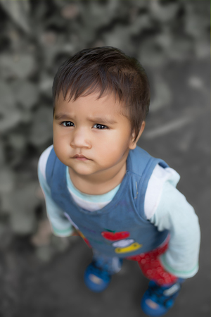 little girl on a green park looking in camera, high angle view with copy spaceの写真素材