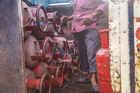 Worker delivering LPG gas cylinders into the truck for customersの写真素材