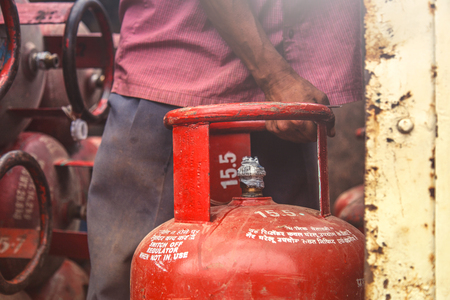 Worker delivering LPG gas cylinders into the truck for customersの写真素材
