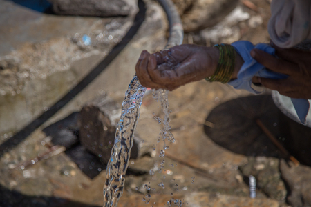 Hands of Poor man Scoop Drinking Waterの写真素材
