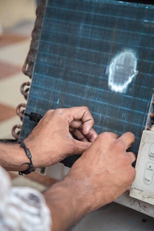 Worker cleaning window air conditioner by water for clean a dust on it in customer home when maintenance service. Breath, repair.の写真素材