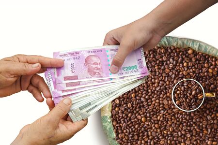 Hand Giving Indian 500 and 2000 Rupee Bank Notes over bag,burlap full of Coffee beans, concept for earnings or spend in Agriculture.の写真素材