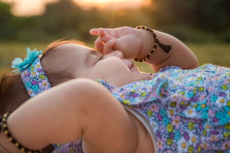 Baby Girl 6 Months Old Lying On Green Grass In The Parkの写真素材