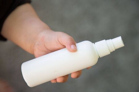 Close up of kid hand holding bottle with antiseptic cleaning gel. Kids use alcohol gel to wash hands to prevent coronavirus, Covid-19. World epidemic crisis.の写真素材