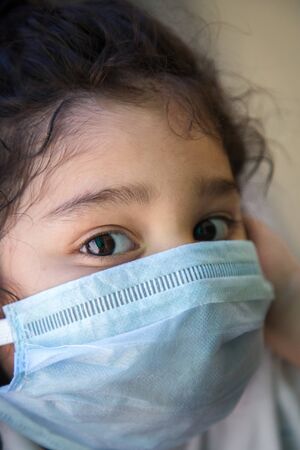 Close up of Indian baby girl wearing the mask for protect them self from virus and air pollution. Prevention by mask to reduce spread of the coronavirus covid-19 outbreak from human to human transmission.の写真素材