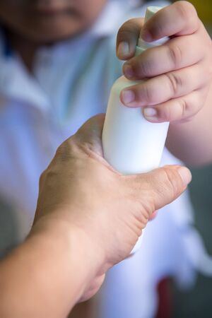 Father and daughter holding antiseptic gel in hands. Flu, illness, pandemic or individual protect on quarantine. Kids use alcohol gel to wash hands to prevent coronavirus, Covid-19. World epidemic crisis.の写真素材