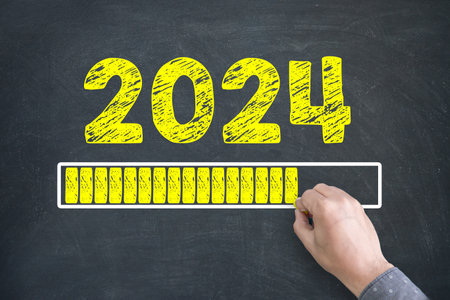 Close up of Human hand Drawing Innovation Technology Loading New Year 2024 on Blackboard Backgroundの写真素材