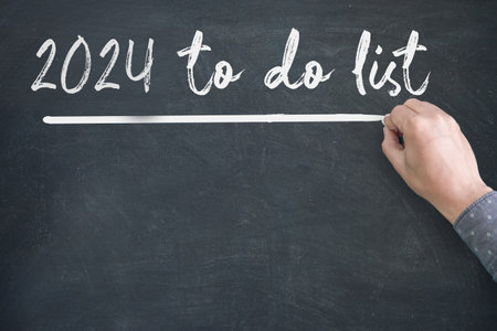 Close up of human hand writing 2024 New Year Resolution Check List on Blackboardの写真素材