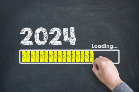 Close up of Human hand Drawing Innovation Technology Loading New Year 2024 on Blackboard Backgroundの写真素材