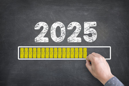 Bright yellow text displays Happy New Year 2025 with a loading progress bar on a blackboard background, symbolizing anticipation and celebration for the upcoming year.の写真素材