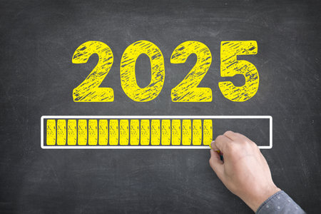Bright yellow text displays Happy New Year 2025 with a loading progress bar on a blackboard background, symbolizing anticipation and celebration for the upcoming year.の写真素材