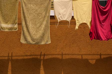 Yellow, Red and Green Washing against Ochre Painted Wallの写真素材