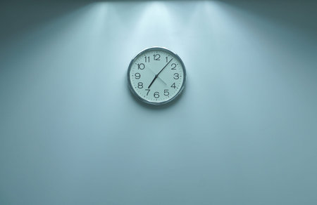 Classic round wall clock on the wall background.